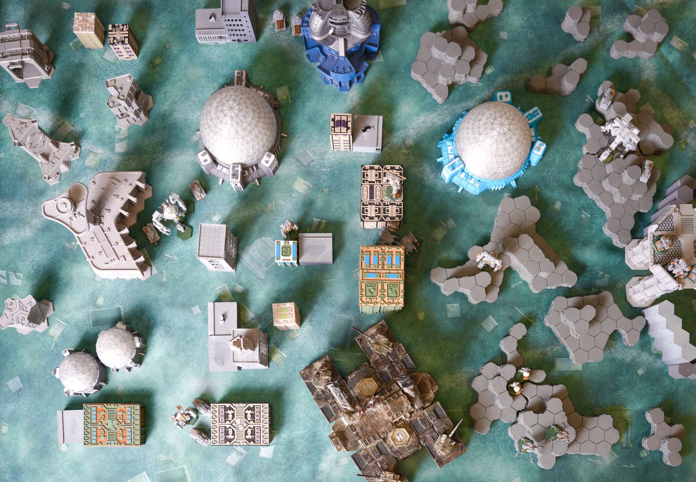 Overhead view of a full BattleTech battlefield with domes, buildings and mechs